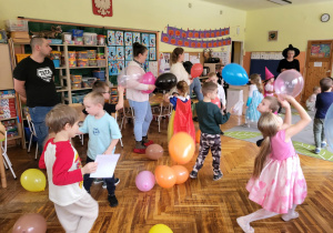 dzieci z rodzicami tańczą z balonami