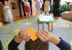 dzieci z rodzicami stoją na dywanie