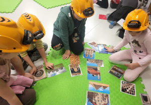 dzieci siedzą w kaskach i układają
