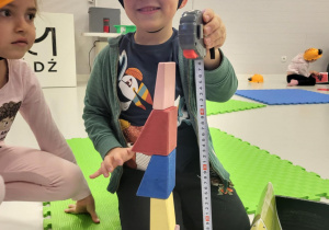 dzieci siedzą w kaskach i układają