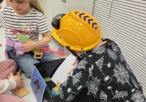 dzieci siedzą w kaskach i układają