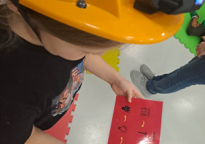 dzieci siedzą w kaskach i układają