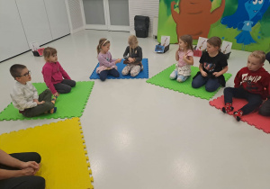 dzieci siedzą na macie