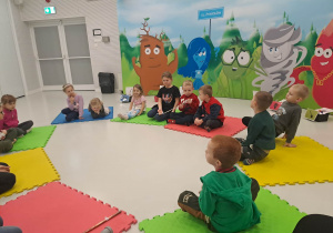 dzieci siedzą na macie