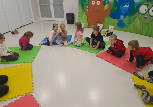 dzieci siedzą na macie
