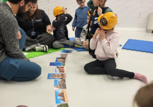 dzieci siedzą w kaskach i układają