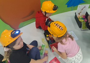 dzieci siedzą w kaskach i układają