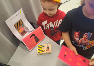 dzieci siedzą w kaskach i układają