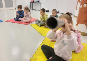 dzieci siedzą na macie