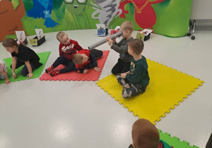 dzieci siedzą na macie