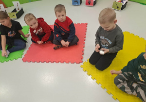 dzieci siedzą na macie