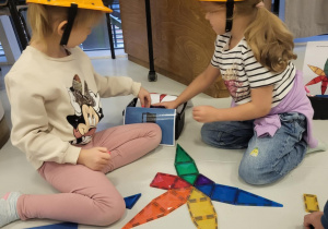 dzieci siedzą w kaskach i układają