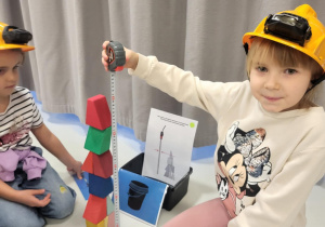 dzieci siedzą w kaskach i układają