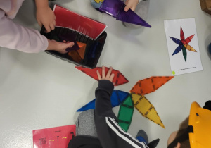 dzieci siedzą w kaskach i układają