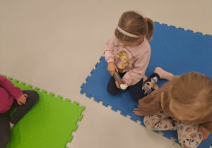 dzieci siedzą na macie