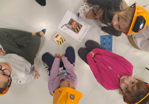 dzieci siedzą w kaskach i układają