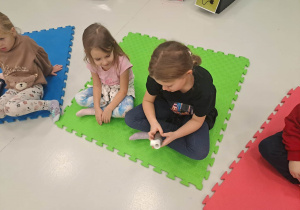 dzieci siedzą na macie