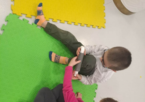 dzieci siedzą na macie