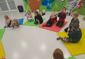 dzieci siedzą na macie