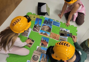 dzieci siedzą w kaskach i układają