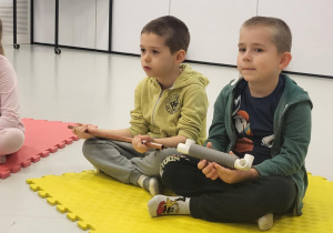 dzieci siedzą na macie