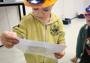 dzieci siedzą w kaskach i układają