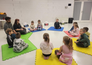 dzieci siedzą na macie