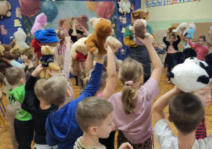 dzieci stoją ze swoimi misiami