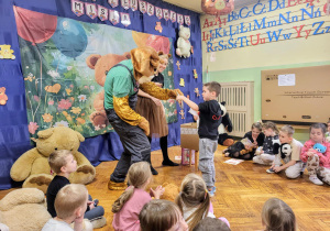 dzieci odbierają dyplomy od misia