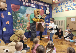 dzieci odbierają dyplomy od misia