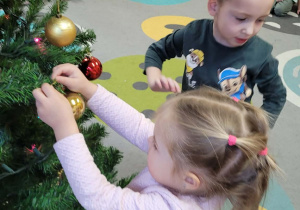 Dzieci ubierają choinkę