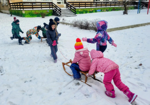 dzieci jadą na sankach