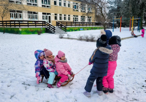 dzieci jadą na sankach