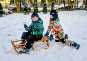 dzieci jadą na sankach