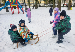 dzieci jadą na sankach