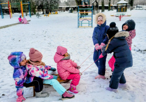 dzieci jadą na sankach