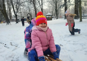 dzieci jadą na sankach