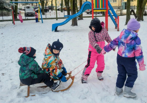 dzieci jadą na sankach