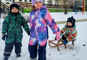 dzieci jadą na sankach