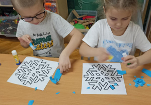 dzieci wyklejają papierem gwiazdkę