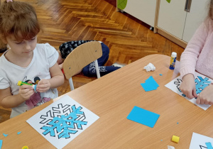 dzieci wyklejają papierem gwiazdkę