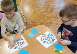 dzieci wyklejają papierem gwiazdkę