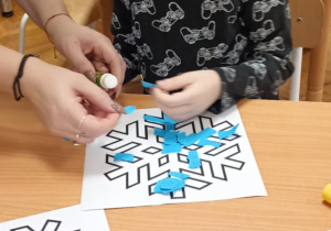 dzieci wyklejają papierem gwiazdkę