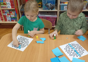 dzieci wyklejają papierem gwiazdkę