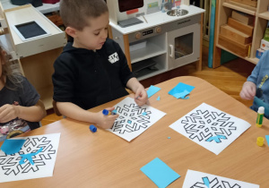 dzieci wyklejają papierem gwiazdkę