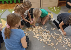 dzieci układaja napis z liter