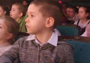 dzieci siedzą w teatrze