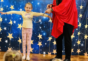 dziewczynka stoi z iluzjonistą