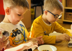 Dzieci przygotowują jedzenie dla ptaków