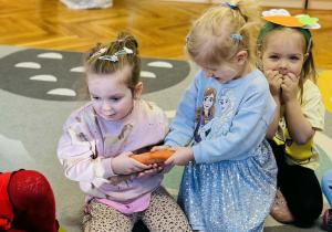 Dzieci bawią się z marchewką